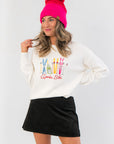 Après Ski White Embroidered Sweater with colorful ski gear design, cozy knit fabric, and relaxed fit, styled for winter layering.