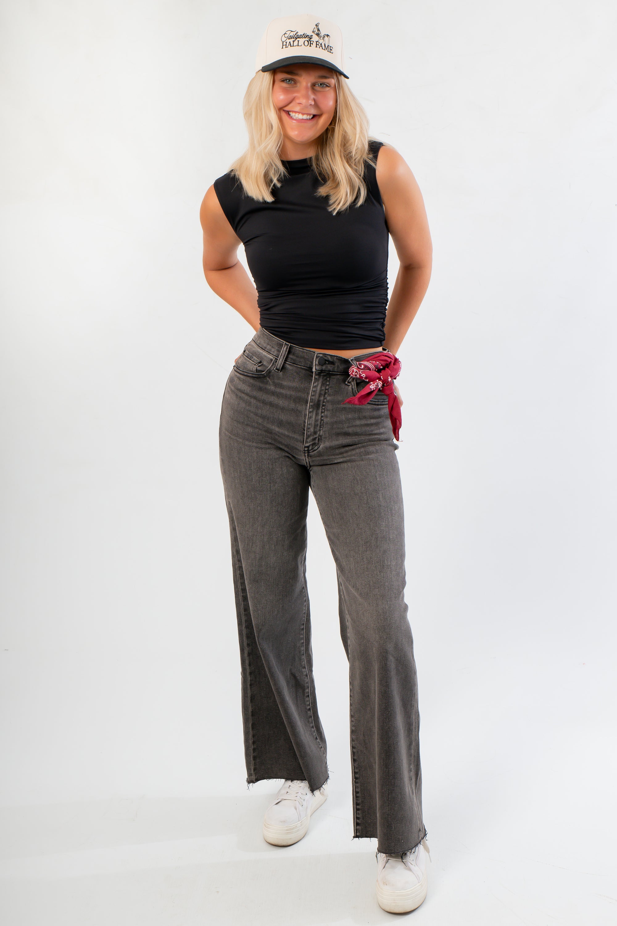 Model wearing Luck Of The Draw Black Ruched Funnel Neck Tank – Sleek Fit with high-waisted grey jeans, perfect for gameday or casual fall looks.
