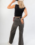 Back view of Luck Of The Draw Black Ruched Funnel Neck Tank – Sleek Fit showing fitted silhouette and sleeveless cut, styled with casual denim.