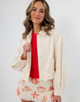 Seagarden Appliqué Floral Detail Jacket in ecru with button front and floral appliqué, paired with a red top and shell-print skirt for spring.