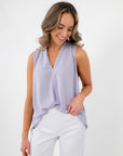 Lavender Mist V-Neck Sleeveless Drape Top styled with white pants, showcasing its soft drape and dressy tank blouse design.