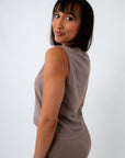 woman in taupe sleeveless tank top, side view with shoulder turned