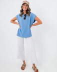 Model wearing Camila Powder Blue Knit Top with hands on hips, showcasing its breezy silhouette and versatile spring style for casual outfits.