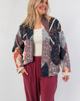 Augusta Patchwork Quilted Jacket in navy and red with geometric fall patterns, styled with relaxed fit and front pockets for cozy layering.