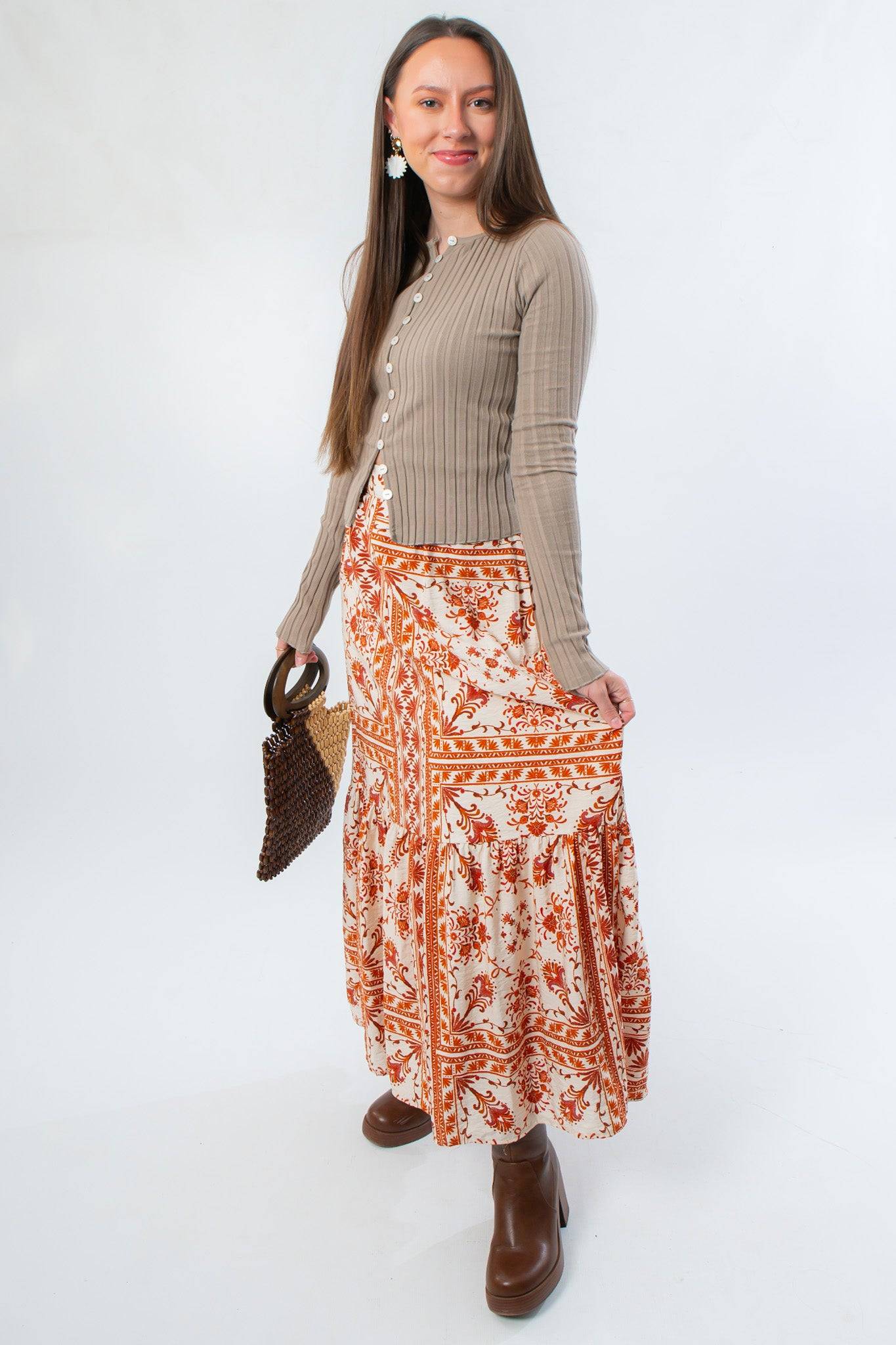 Side view of Burnt Orange Floral Patterned Midi Skirt styled with brown boots and long sleeve top. A must-have for fall fashion lovers.