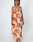 Woman in boho seashell print maxi dress with shell jewelry