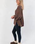 Side profile of Camden Brown Ribbed Knit Mockneck Top showing loose fit and ribbed texture, paired with leggings and clogs.