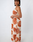 Back view of woman in seashell leaf print maxi dress with shell jewelry