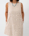 Close-up of cream dress with sequin embellishments, sleeveless, summer party dress