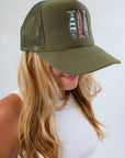Woman in white tank top modeling Sardines Olive Trucker Hat – Embroidered Snapback for Fall, featuring mesh back and colorful sardine design.