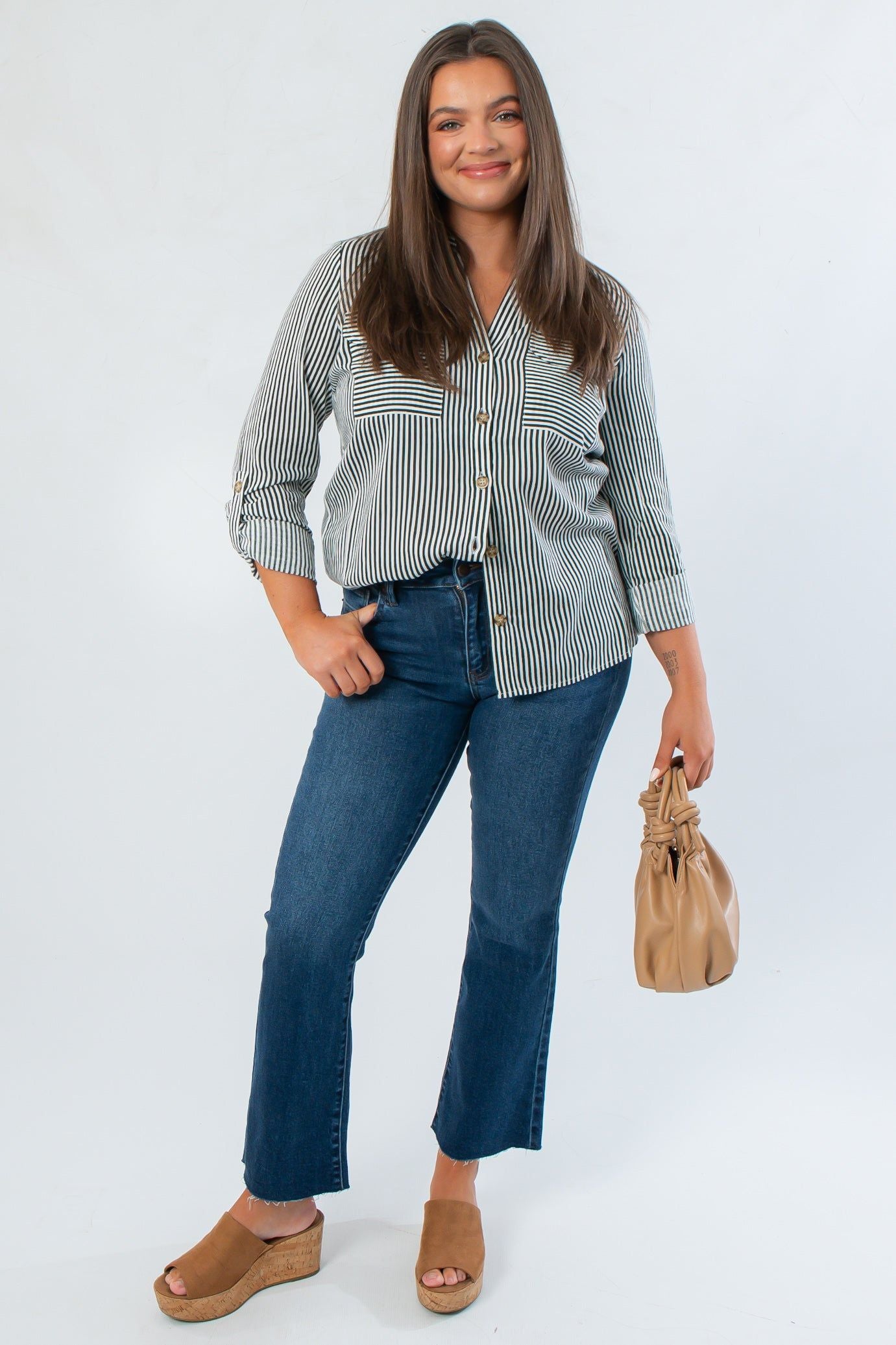 Dark Green Striped Button Down blouse paired with flared jeans and wedge sandals, showcasing a chic fall workwear look.
