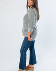 Side view of Dark Green Striped Button Down with rolled sleeves, highlighting its relaxed fit and vertical stripe pattern for fall layering.