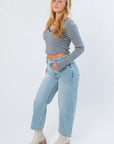 Side view of Before You Go Blue Stripe Long Sleeve Crop Top featuring asymmetrical hem and fitted sleeves, styled with casual denim and boots.