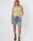 Full view of Free People Weeping Willow Tilly Vest, a sleeveless boho top paired with denim shorts, boots, and a cap for effortless spring layering.