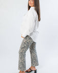 Side view of Rylee White Oversized Button Down Shirt showcasing its loose silhouette and long sleeves, styled for modern workwear.