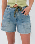 Free People Truest Blue Moxie Shorts with front patch pockets and raw hem in light wash denim, ideal for casual summer wear.