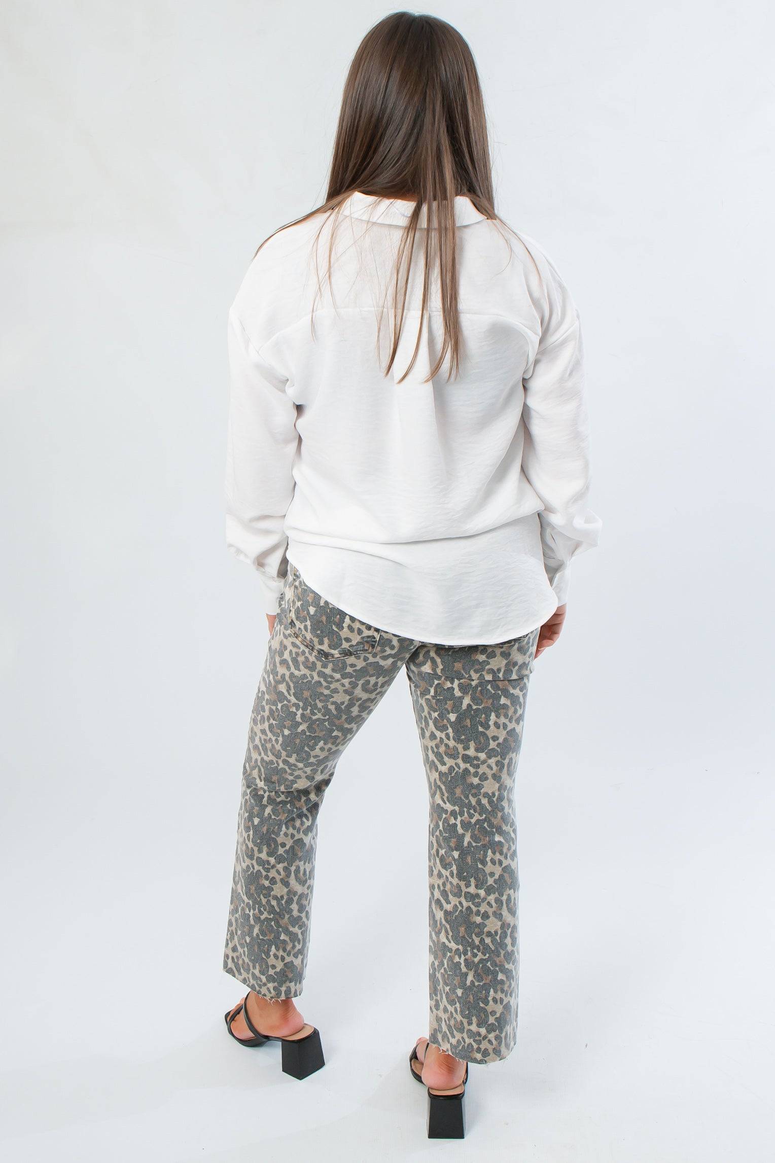 Back view of Rylee White Oversized Button Down Shirt highlighting its flowy design and curved hem, perfect for versatile styling.