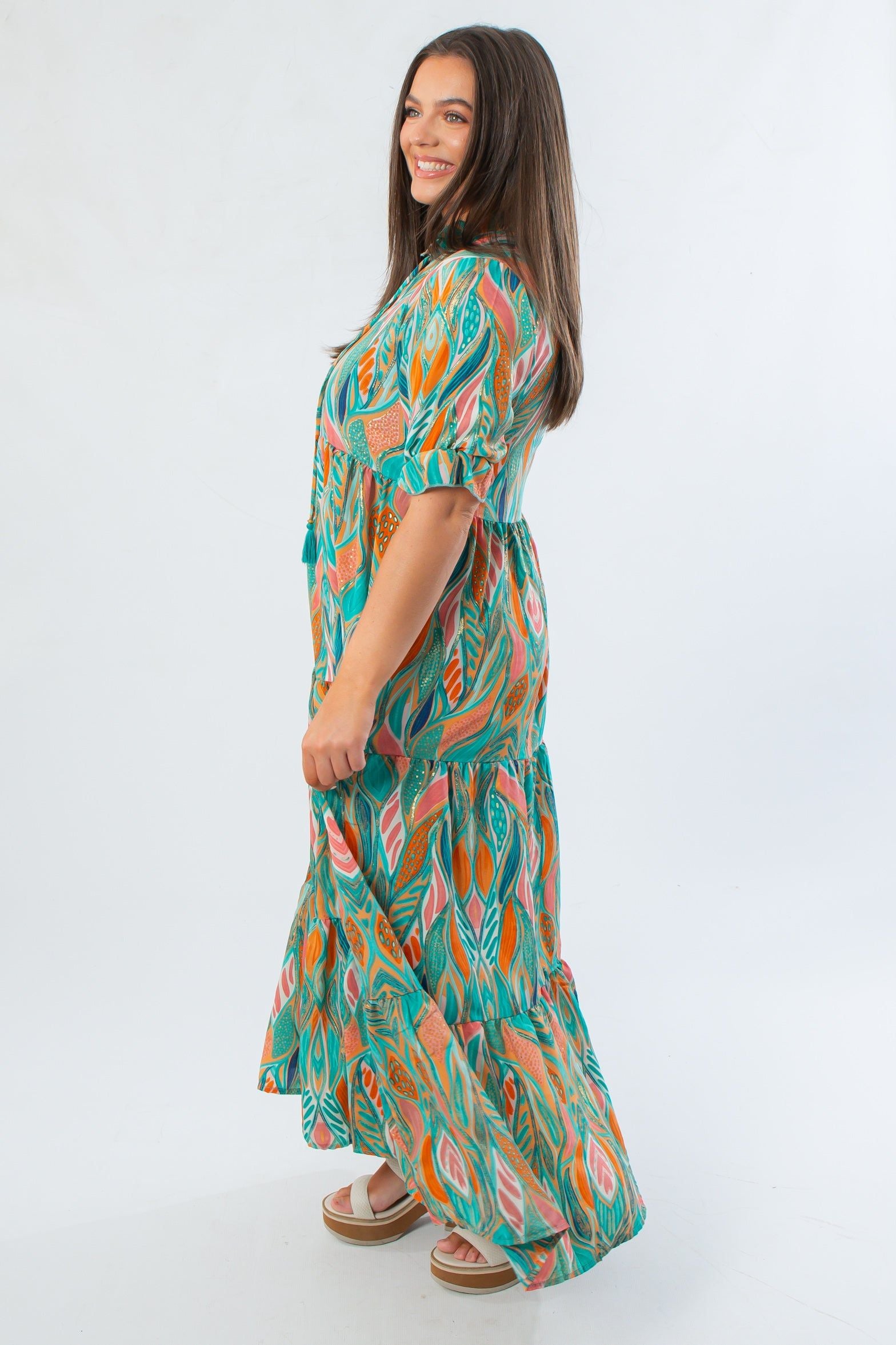 Side view of Mahi Sea Foam Green Maxi Dress showcasing tiered silhouette and puff sleeves with a flowing, lightweight fabric.