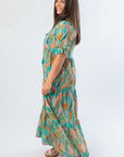 Side view of Mahi Sea Foam Green Maxi Dress showcasing tiered silhouette and puff sleeves with a flowing, lightweight fabric.