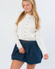 Cream Cable Knit Button Front Cardigan – Cozy Fall Essential featuring a cropped fit and ribbed texture, styled with a navy skirt for fall fashion.