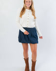 Cream Cable Knit Button Front Cardigan – Cozy Fall Essential paired with a denim skirt and brown boots, ideal for layered autumn outfits.