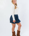 Side view of Cream Cable Knit Button Front Cardigan – Cozy Fall Essential showing slim fit and textured knit, styled with a bubble hem skirt.