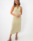 woman in beige textured halter midi dress with gold necklace and platform sandals