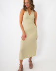 woman in beige textured halter midi dress with gold jewelry and platform sandals