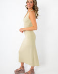 woman in textured sage green halter midi dress with chunky platform sandals
