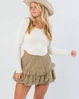 Before You Go Cream Long Sleeve Crop Top – Chic & Comfortable ribbed knit top with V-neck and asymmetrical hem, styled with a khaki ruffle skirt.