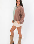 Side view of Road Ahead Mint & Brown Colorblock Sweater showing relaxed fit and soft knit texture, styled with neutral mini skirt.