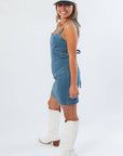 Side view of Karli Denim Corset Back Mini Dress highlighting its flattering fitted silhouette and casual gameday appeal.