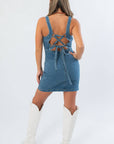 Back view of Karli Denim Corset Back Mini Dress featuring adjustable lace-up corset detail for a custom fit and stylish finish.
