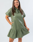 THML Olive Puff Sleeve Faux Leather Mini Dress with bow tie neck and ruffled hem, perfect for fall fashion and Thanksgiving events.