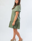 Side view of THML Olive Puff Sleeve Faux Leather Mini Dress showcasing relaxed fit and gathered hemline for a chic fall look.