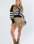 VM Black and White Stripe Cardigan paired with a tan ruffle skirt and brown boots, perfect for gameday or casual fall outfits.
