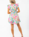 Rear view of Meet Me in Santorini Aegean Garden Dress showing cinched waist and flowy skirt in multicolor floral pattern.