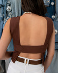 Side view of woman in brown open back tank top with denim jackets and disco ball decorations
