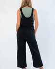 Back view of Z Supply True Black Everyday Jersey Jumpsuit with wide straps and relaxed silhouette, perfect for layering and casual outfits.