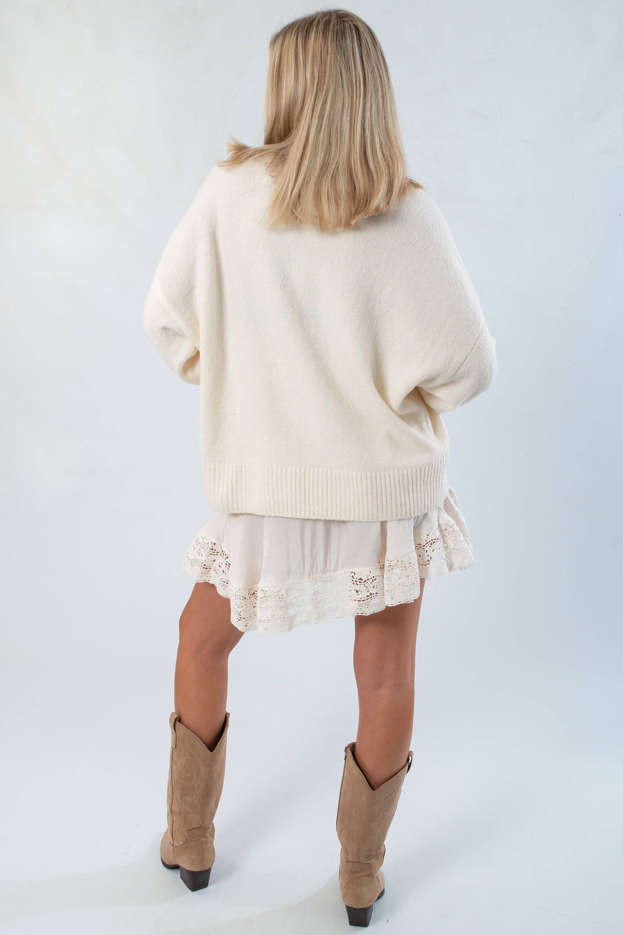 Back view of the Almost September Off White Cream Oversized Sweater highlighting its loose silhouette and ribbed hem for casual fall outfits.