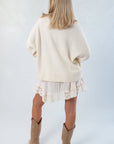 Back view of the Almost September Off White Cream Oversized Sweater highlighting its loose silhouette and ribbed hem for casual fall outfits.