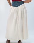 Back view of Show Me Your Mumu Denim Voile Maxi Skirt showing pleated cream fabric and V-shaped denim waistband detail.