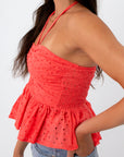 Back view of coral eyelet halter top with tie closure and smocked detail