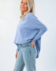 Side view of Free People Dawn Breeze Latte Blues Solid Thermal showing loose fit and curved hem, ideal for casual winter and fall outfits.