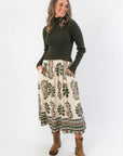 Channing Olive Green Contrast Midi Dress with ribbed knit bodice and printed skirt, styled with brown ankle boots for fall fashion.