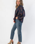 Side view of At Long Last Navy Long Sleeve Blouse showcasing voluminous floral sleeves and relaxed fit, styled with denim and leopard print shoes.