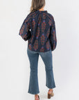 Back view of At Long Last Navy Long Sleeve Blouse highlighting smocked detailing and vintage floral print on navy fabric with balloon sleeves.