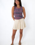woman wearing beige skort with striped tank top and sandals