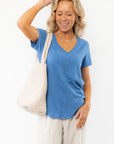 Z Supply Asher V-Neck Tee in Riviera Blue styled with a textured tote and striped pants, perfect for casual spring and summer outfits.