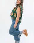 Side view of THML Dark Green Ruffle Sleeve Block Floral Print Blouse showcasing floral pattern and ruffle sleeves, paired with denim and wedges.